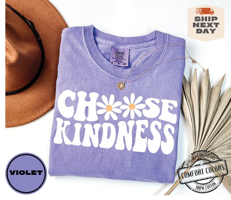 May include: Purple t-shirt with the text "Choose Kindness" in white with a daisy graphic. The shirt is made of 100% cotton.