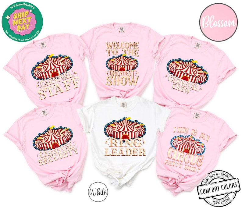 May include: Pink and white t-shirts with circus-themed designs. The shirts feature a circus tent graphic with text such as "Carnival Staff," "Greatest Show," and "Ring Leader." The shirts are made of 100% cotton.