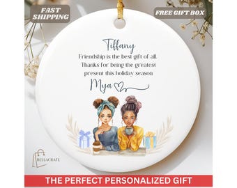 May include: White round ornament with a blue and white illustration of two women holding mugs. The text reads "Tiffany Friendship is the best gift of all. Thanks for being the greatest present this holiday season Mya"