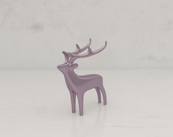 May include: A metallic lavender-colored deer figurine with large antlers. The decorative sculpture is standing on a white surface, with a light gray background. The deer is a minimalist design, suitable for home decor.