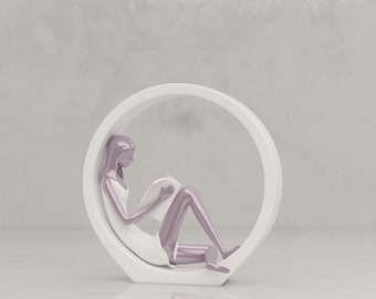 May include: A white ceramic sculpture of a person sitting in a circular frame. The person is wearing a white dress and has pink skin.