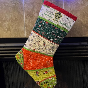 May include: A green, red, and white Christmas stocking with a Grinch theme. The stocking has a quilted design and features the text "Do I look like a people person? Unhappy Holidays" and "Let's just not.  You're a mean one, Mr. Grinch.  Regifter".