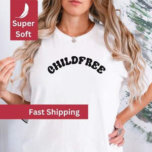 May include: White t-shirt with the text "CHILD FREE" in a retro font.
