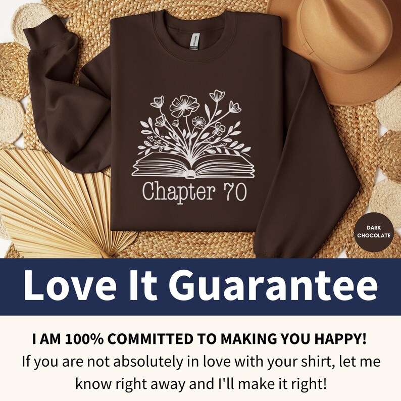 May include: A brown sweatshirt with a white design of a book with flowers growing out of it. The text "Chapter 70" is printed below the book. The sweatshirt is on a woven straw background.