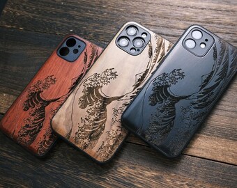 May include: Three wooden phone cases with a wave design. The cases are in shades of red, tan, and black. The wave design is etched into the wood. The cases are on a dark wood surface.