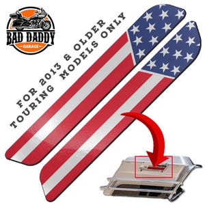 May include: Pair of motorcycle saddlebag lid accents with a US flag design. The accents feature red and white stripes with a blue field of white stars. The text reads "FOR 2013 & OLDER TOURING MODELS ONLY". The Bad Daddy Garage logo is in the upper left corner.