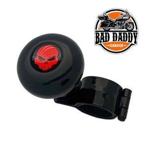 May include: Black steering wheel knob with a red skull design. The knob is attached to a black metal clamp. The text "BAD DADDY GARAGE" is visible in the background.