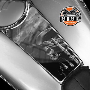 May include: Black and white gas tank graphic decal featuring a skull with a pirate hat and a hand giving the middle finger. The decal has a smoky background and the text "Bad Daddy Garage" in a circle.
