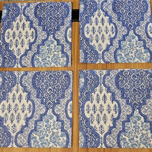 Op de afbeelding: Vier vierkante onderzetters met een herhalend blauw-wit patroon. Het ontwerp bestaat uit complexe, in elkaar grijpende geometrische vormen gevuld met gestileerde bloemen- en plantmotieven, wat zorgt voor een samenhangend visueel thema voor alle vier.