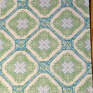 May include: A patterned design featuring a repeating motif of green and light blue floral elements within a diamond grid. The design is set against a white background. The text "Lilly Pulitzer" is visible in the bottom corner.