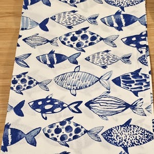 May include: White fabric with a blue and white fish pattern. The fish are stylized and have different patterns, including stripes, dots, and swirls.