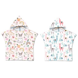 May include: Two hooded towels, one with a pink bunny rabbit pattern and the other with a white llama pattern. Both towels have a white background.