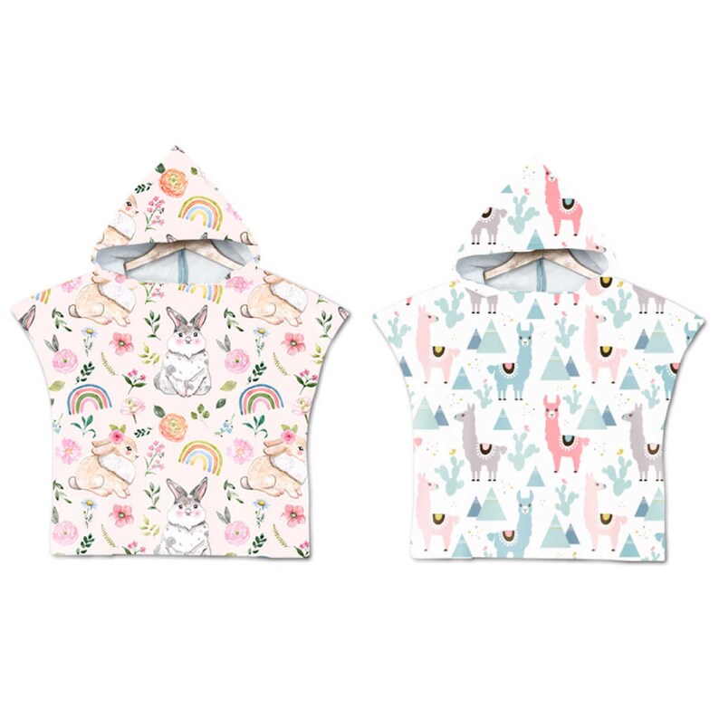 May include: Two hooded towels, one with a pink bunny rabbit pattern and the other with a white llama pattern. Both towels have a white background.