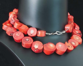 Könnte beinhalten: Eine rote Korallenkette mit runden Perlen und einem silbernen Verschluss.