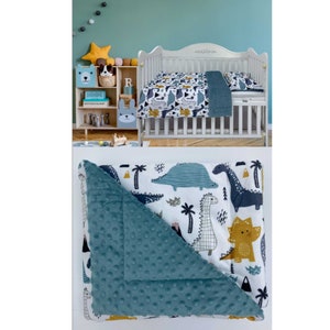 May include: A blue and white dinosaur themed baby blanket with a soft, plush, blue side. The blanket features a variety of dinosaurs, palm trees, and other jungle-themed elements.