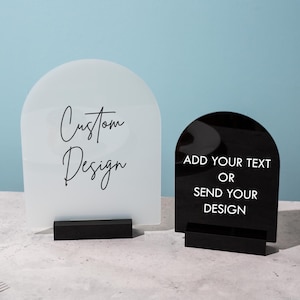 May include: Two arched acrylic signs with black bases. One is frosted with "Custom Design" in script. The other is black with white text that reads "Add Your Text Or Send Your Design".