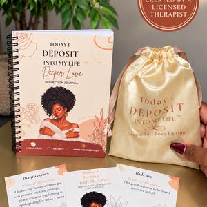 May include: A spiral-bound reflection journal titled Today I Deposit Into My Life Deeper Love, a gold satin drawstring pouch, and three affirmation cards. The journal and cards feature an illustration of a person with dark curly hair.