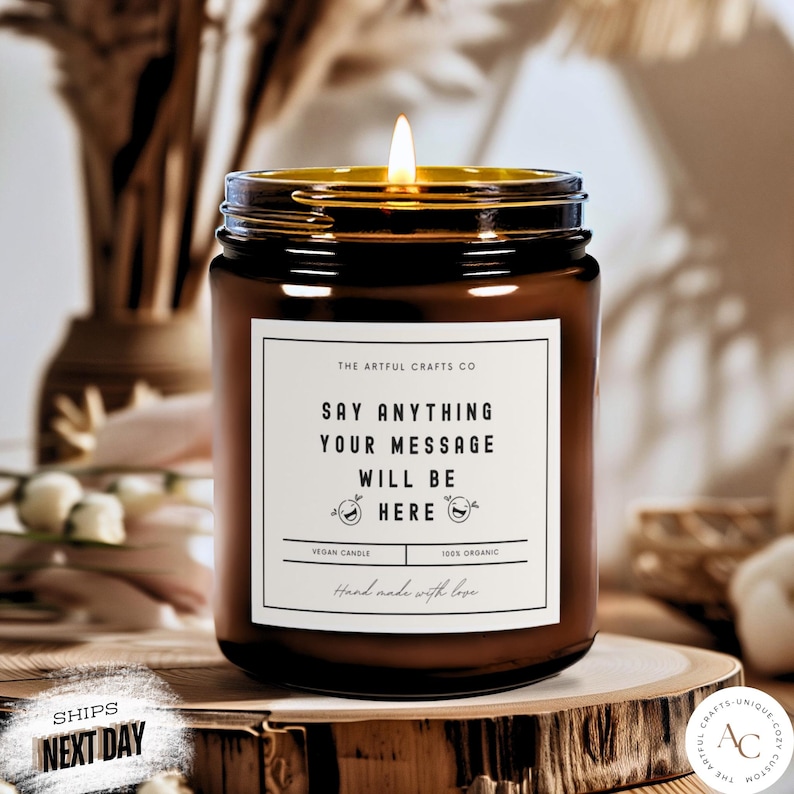 May include: A brown glass candle jar with a white label that says "The Artful Crafts Co. Say Anything Your Message Will Be Here Vegan Candle 100% Organic Hand Made with Love".