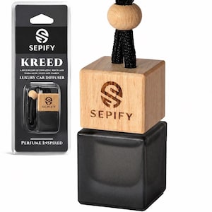 Könnte beinhalten: Ein Luxus-Autodiffusor der Marke Sepify mit einer quadratischen schwarzen Glasflasche und einem hellen Holzdeckel, der mit dem Sepify-Logo graviert ist. Eine schwarze Kordel mit einer runden Holzperle ist oben befestigt. Produkt in Verkaufsverpackung.