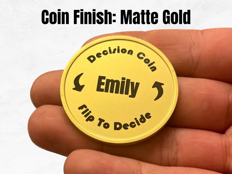 May include: A gold-colored coin with the text "Decision Coin" and "Flip To Decide" around the edge. The name "Emily" is in the center of the coin.