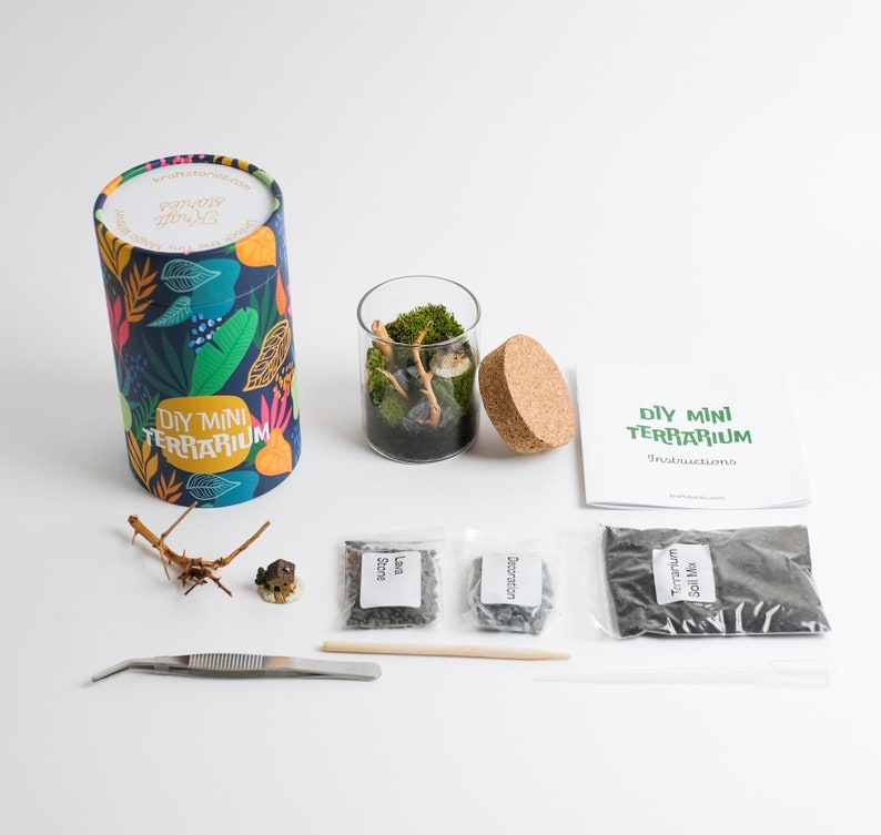 Pu&ograve; includere: Kit per terrario in miniatura fai-da-te con un barattolo di vetro, un tappo di sughero, istruzioni e una variet&agrave; di materiali tra cui terra, pietra lavica e muschio decorativo. Il kit &egrave; fornito in un contenitore cilindrico colorato con le parole "DIY Mini Terrarium" stampate su di esso.