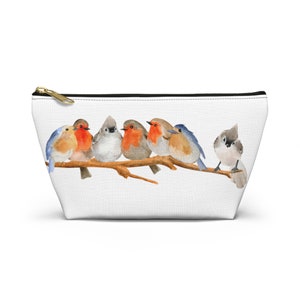 Puede incluir: Una bolsa blanca con cremallera que presenta una ilustración de acuarela de seis pájaros posados en una rama. Los pájaros son una mezcla de azul, rojo y marrón con detalles blancos. La bolsa es perfecta para llevar objetos pequeños como maquillaje, joyas u otros artículos esenciales.