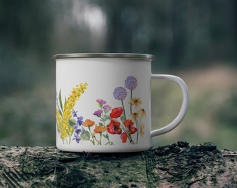 May include: White enamel mug with a floral design featuring yellow, red, purple, and green flowers. The mug has a silver rim and handle.