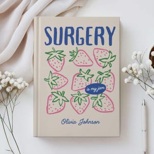 May include: A beige journal with the word "SURGERY" in blue, and illustrations of pink strawberries with green stems. The phrase "is my jam" is in a blue oval, and the name "Olivia Johnson" is at the bottom.