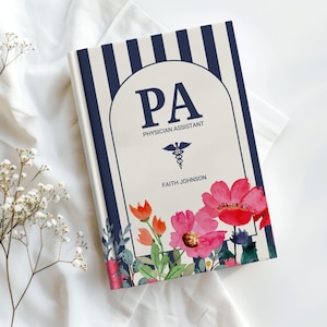 May include: A hardcover notebook with a navy blue and white striped design. The cover features the letters "PA" above "Physician Assistant" and a medical symbol. Floral illustrations in pink, red, and orange adorn the bottom. The name "Faith Johnson" is printed below.