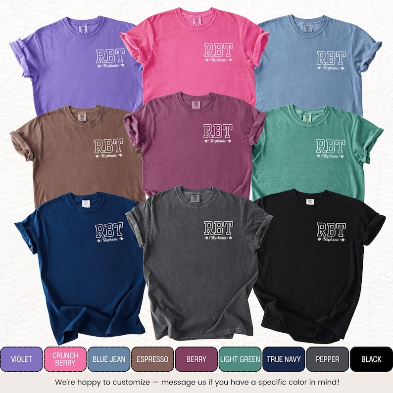 May include: A collection of nine short-sleeved t-shirts in various colors, including violet, pink, blue, brown, green, and black. Each shirt features the letters "RBT" and the name "Stephanie" in white lettering. The bottom of the image displays color names.