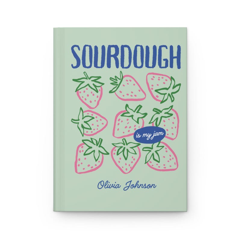 Puede incluir: Un diario verde claro con la palabra "SOURDOUGH" en azul y un patr&oacute;n de fresas rosas con hojas verdes. El texto "is my jam" est&aacute; en un &oacute;valo azul, y el nombre "Olivia Johnson" est&aacute; debajo.