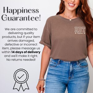 May include: A brown t-shirt with the letters "RBT" in a white, outlined font on the upper chest. The text "Happiness Guarantee!" is at the top left. The shirt is paired with blue jeans.
