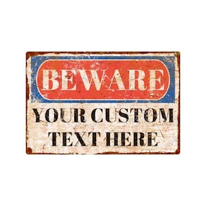Könnte beinhalten: Ein Vintage-Schild aus Metall mit rotem und blauem Rand. Das Schild trägt die Aufschrift "BEWARE" in großen weißen Buchstaben und "YOUR CUSTOM TEXT HERE" in schwarzen Buchstaben.