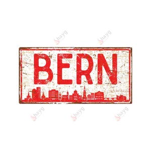May include: A rectangular, distressed metal sign with the word "BERN" in large, red, capital letters. Below the text is a red silhouette of a city skyline. The sign has a white background with a weathered, vintage appearance.