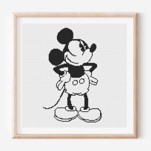 May include: Black and white cross-stitch of Mickey Mouse in a wooden frame. Mickey is standing with his hands on his hips, wearing white gloves, shoes, and shorts. The background is a white grid.