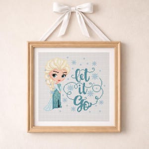 Può includere: Opera d'arte a punto croce di un personaggio dei cartoni animati in un vestito blu con i capelli biondi, incorniciata in una cornice di legno chiaro. Il testo "let it go" è scritto in blu con accenti di fiocchi di neve. L'opera è sospesa da un nastro bianco.