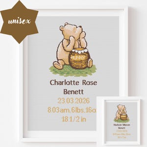 May include: A framed cross-stitch art piece featuring a light brown bear sitting beside a honey pot labelled HUNNY. Below the bear, the text reads Charlotte Rose Benett, 23.03.2026, 8.03am, 6lbs, 16oz, and 18.1/2 in, all in brown and gold lettering.