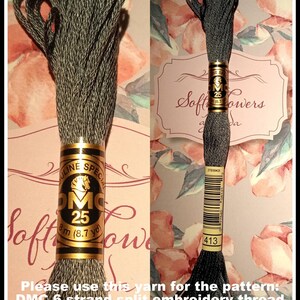 May include: Two spools of DMC embroidery floss in a dark gray color. Each spool is labeled with the DMC logo, the number 25, and the length of the thread, 8 m (8.7 yd). The text "Soft Flowers" is visible on the label.