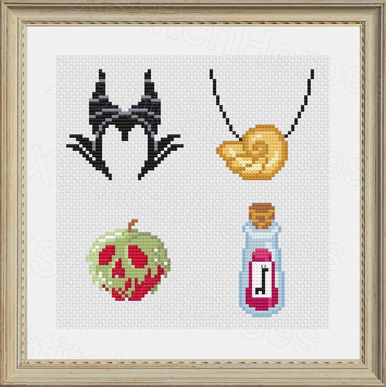 May include: Cross-stitch art featuring four designs: a black horned headdress, a gold seashell necklace, a green and red poison apple, and a potion bottle with a pink label. The designs are set against a white background within a framed presentation.