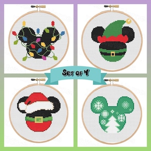 May include: Set of 4 cross-stitch hoops featuring Mickey Mouse designs. Each hoop has a wooden frame and a white background. Designs include Mickey with Christmas lights, an elf hat, a Santa hat, and a green snowflake and tree design.