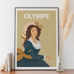 Peut inclure: Une affiche encadrée représentant une femme en robe bleu foncé et grand chapeau, avec le mot "OLYMPE" en haut. L'illustration a un style vintage, sur fond neutre. L'œuvre est présentée sur une surface en bois.