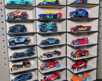 Pode incluir: Uma prateleira de madeira com 18 slots para guardar carros de brinquedo. A prateleira é feita de madeira marrom com acabamento preto. A prateleira é inclinada para criar um efeito escalonado. A prateleira está vazia, mas o texto "DIGITAL FILE ONLY TOY CARS ARE NOT INCLUDED" é impresso abaixo da prateleira.
