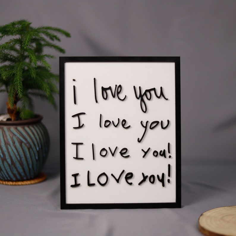 May include: A black framed whiteboard with the words "i love you" written four times in black marker.