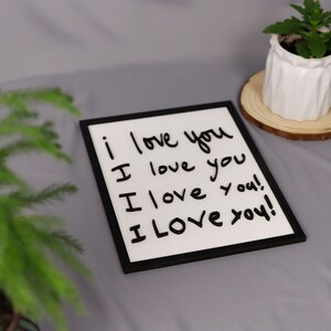 May include: A black framed white board with the words "i love you" written on it four times in black marker.
