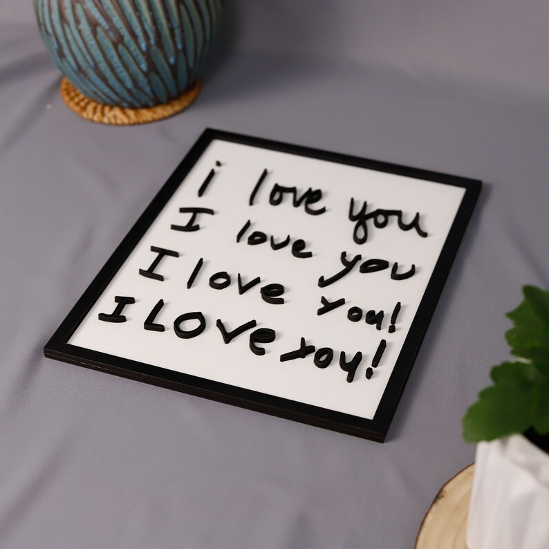 May include: A white framed dry erase board with the words "I love you" written on it four times in black marker.