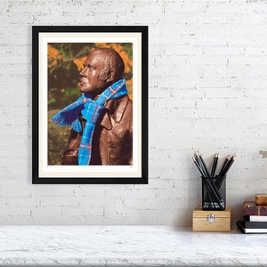 ‘Hap Up, Rabbie!’ art print, A3 size, mounted and framed, shown on a wall. A statue of Scots bard Robert (Rabbie) Burns with a colourful scarf wrapped around it.