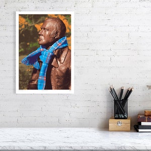 ‘Hap Up, Rabbie!’ art print, A3 size, unframed, shown on a wall. A statue of Scots bard Robert (Rabbie) Burns with a colourful scarf wrapped around it.