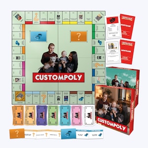 May include: A custom board game set titled Customopoly featuring a game board with a central photo of a family and a dog, game cards, paper money in various colors, and a game box displaying the same family photo and the Customopoly brand name.
