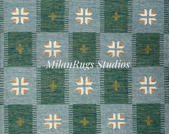 Puede incluir: Una alfombra tejida con un patrón repetitivo de cuadrados en verde azulado y verde. Cada cuadrado contiene un diseño en forma de cruz en blanco y marrón claro. El texto "MilanRugs Studios" es visible en la alfombra.