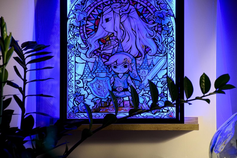 Puede incluir: Una obra de arte de estilo vitral con un esquema de colores azul y morado. La obra representa a un personaje femenino con el pelo largo y rubio y un personaje masculino con una espada. La obra est&aacute; enmarcada en un marco de madera oscura.